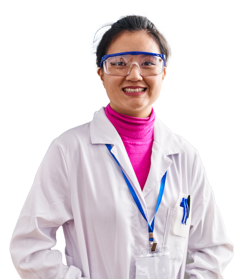 Woman in lab coat and goggles smiling with her hands in her pockets