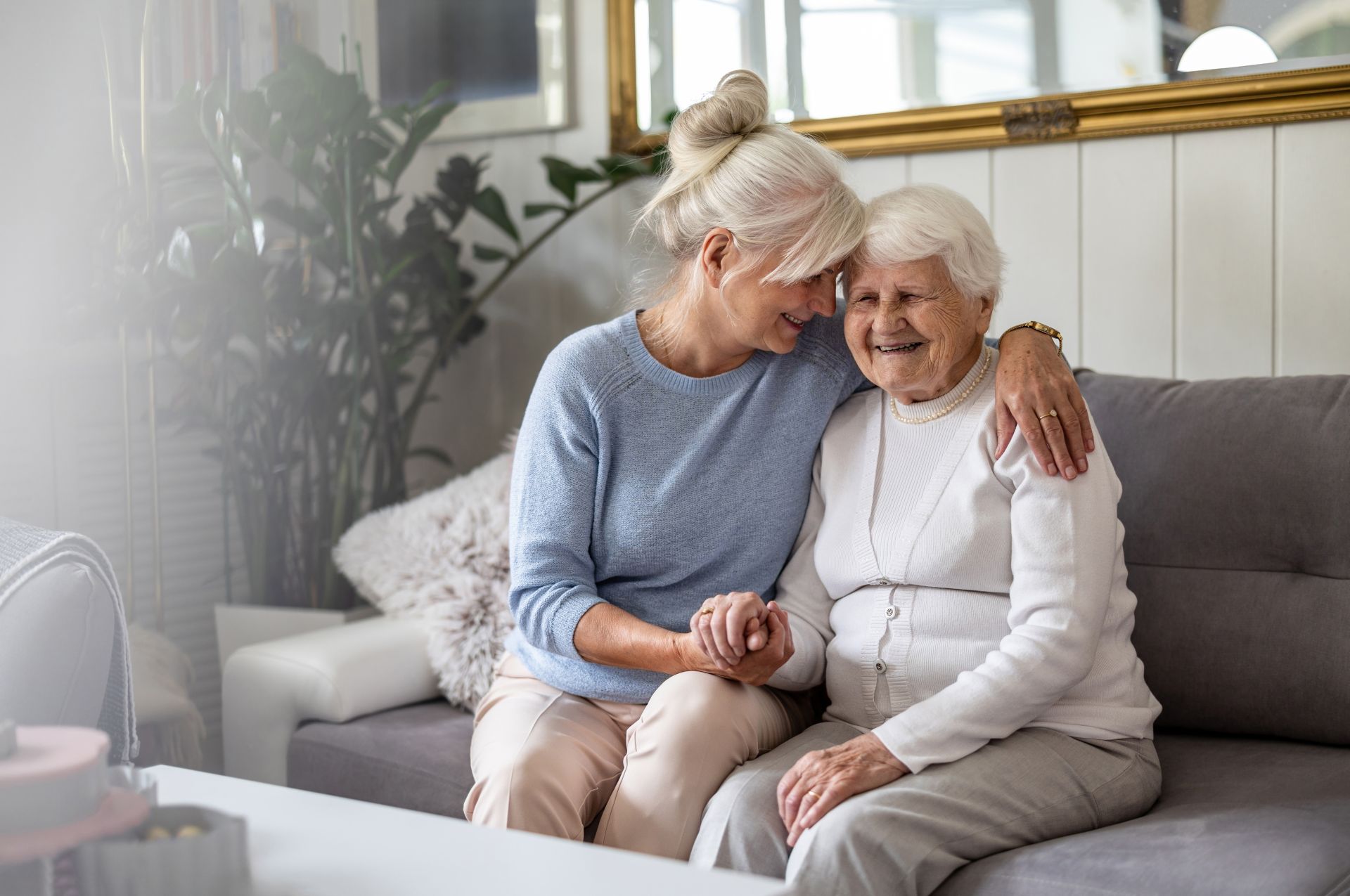 Glückliche Seniorin mit ihrer Tochter zu Hause als Symbolbild für die Teilnahme an einem kostenfreien Online-Pflegekurs zur häuslichen Pflege