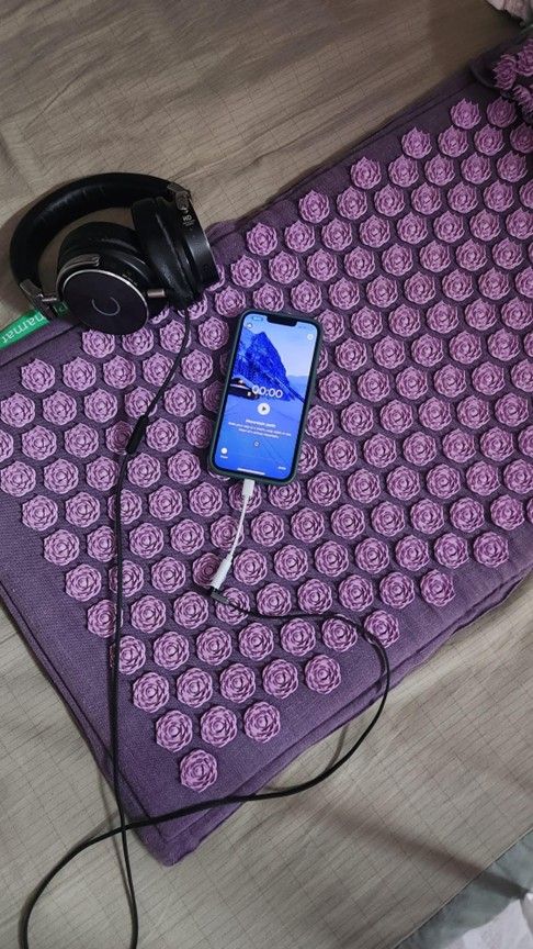 A Pranamat on the floor, with the Envol App ready to play a 3D Sound Journey on a mobile phone, and a headset.