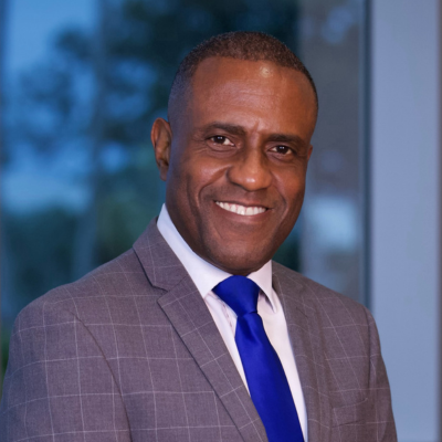 Dr. Steven Smith standing, wearing grey suit and blure tie