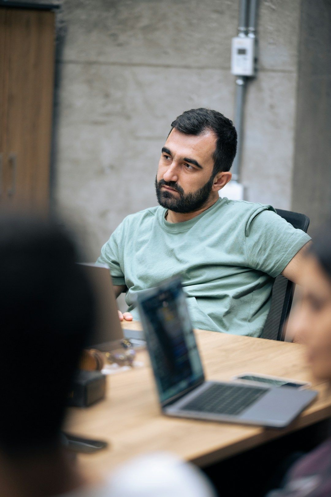 Manager in team meeting listens to colleague