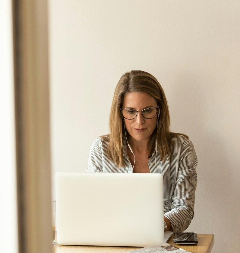 Female manager works at laptop in cafe whilst learning online