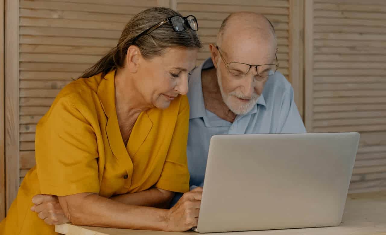 elderly couple in front of the laptop