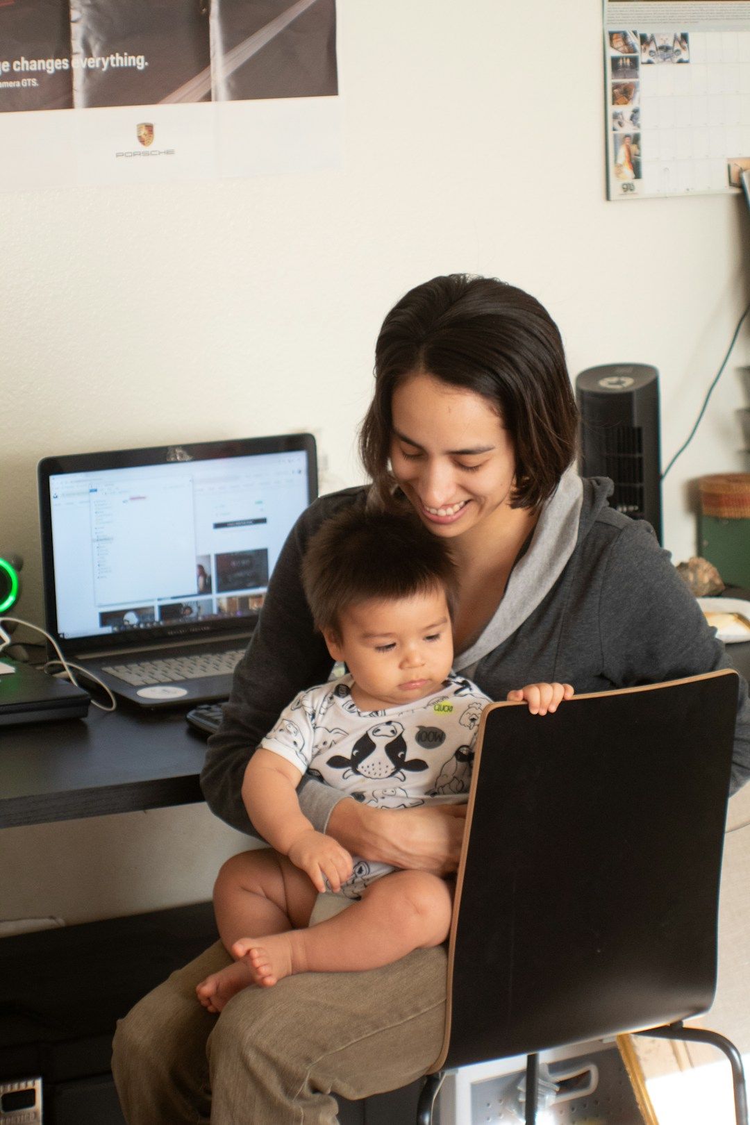 Lisa M. with her toddler son in front of her laptop