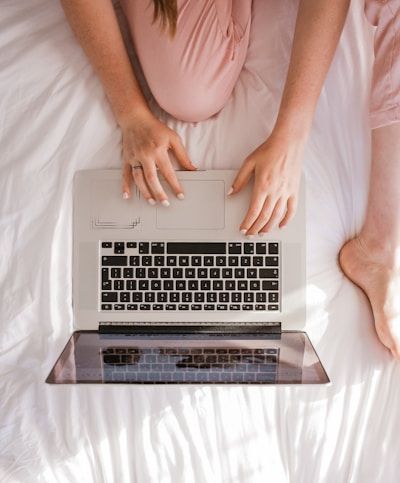 woman on a laptop sitting on a bed