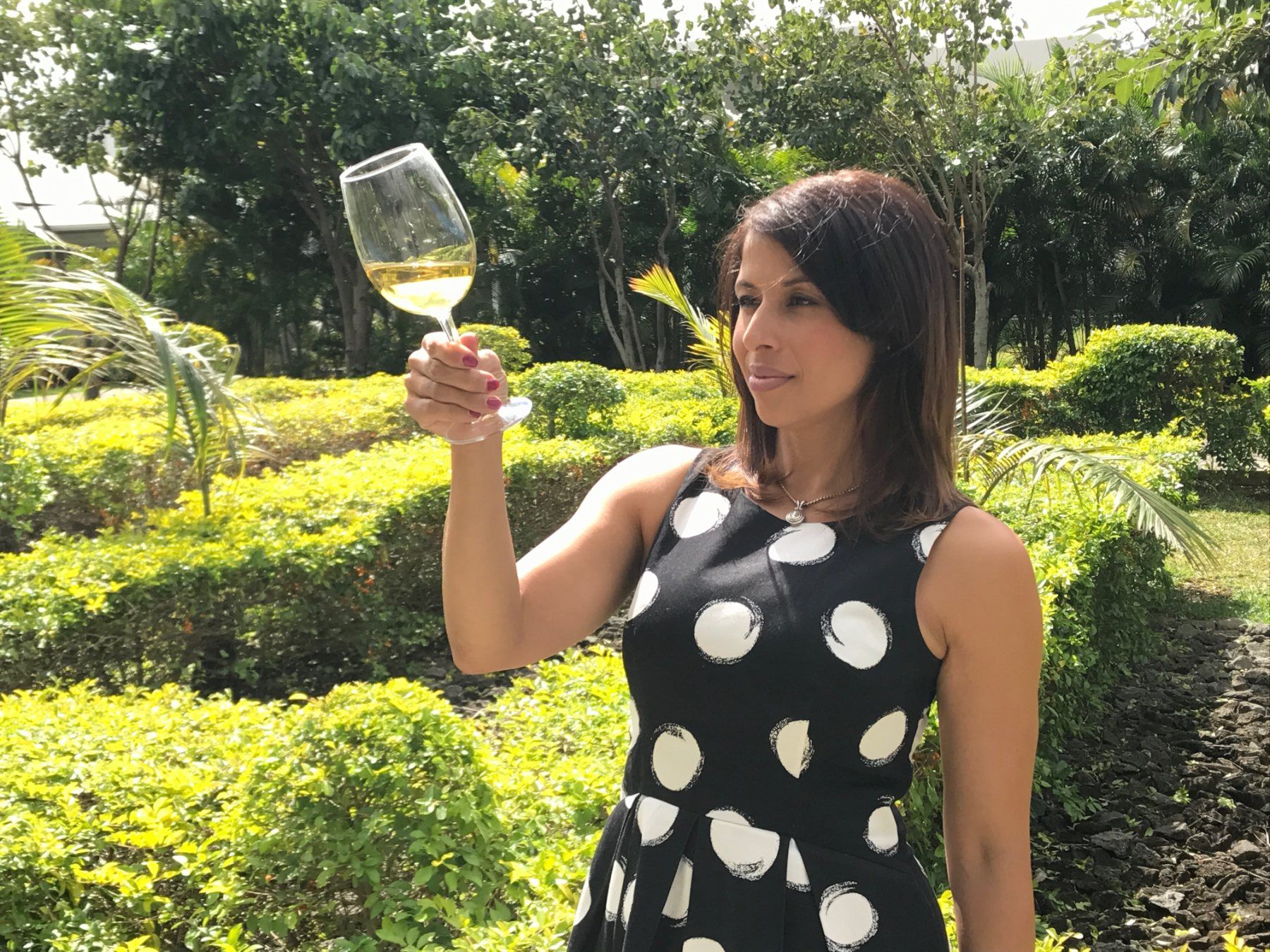 Dolly Duran examining a glass of white wine