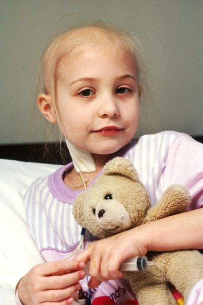 girl with cancer holding teddy bear