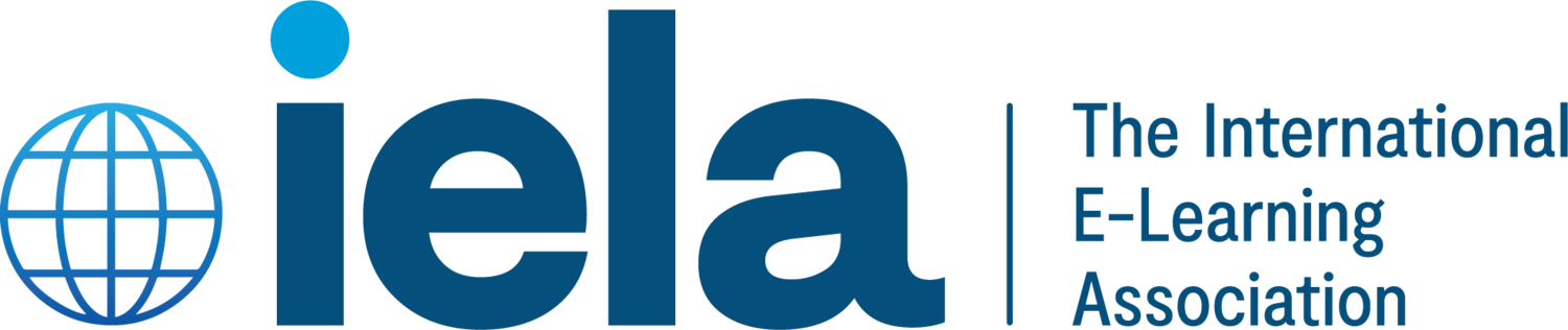 Logo of the International E-Learning Association (IELA) featuring a stylized globe symbol on the left, accompanied by the text 'iela' in bold blue letters and the tagline 'The International E-Learning Association' in smaller text to the right.