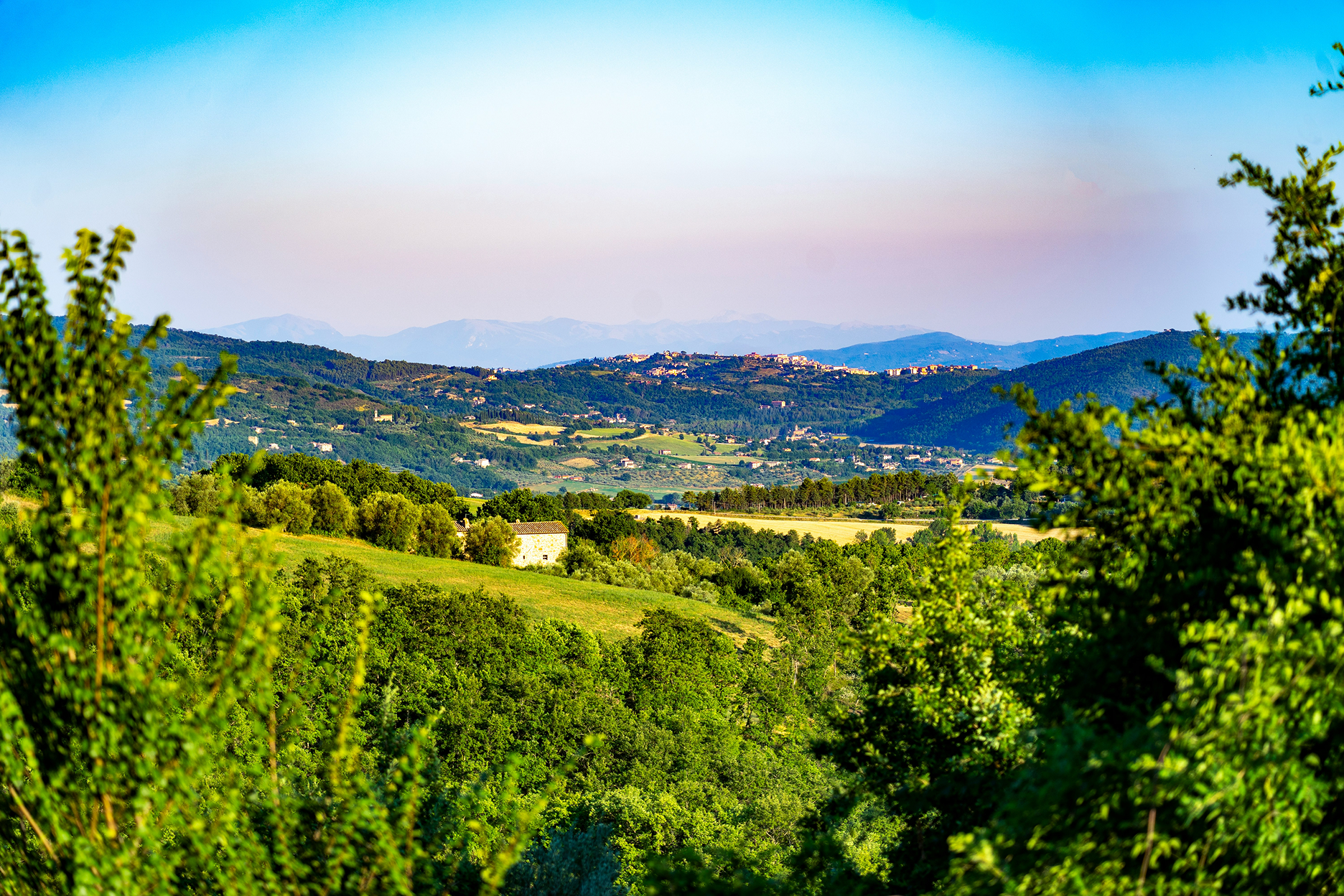 A scenic view of rolling hills beneath a vibrant sunset sky.