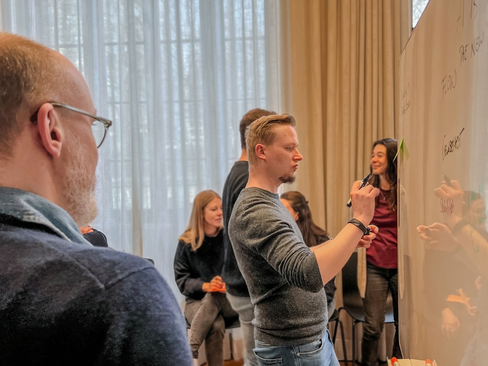 zero360-Berater:innen während eines Workshops im Haus Lademann in Berlin, bei der interaktiven Arbeit an einem Whiteboard.
