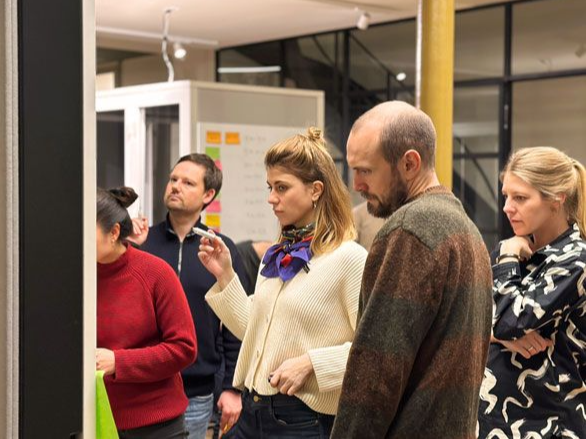 zero360-Berater:innen während eines Workshops im Haus Lademann in Berlin, konzentriert vor einem Whiteboard in der Diskussion.