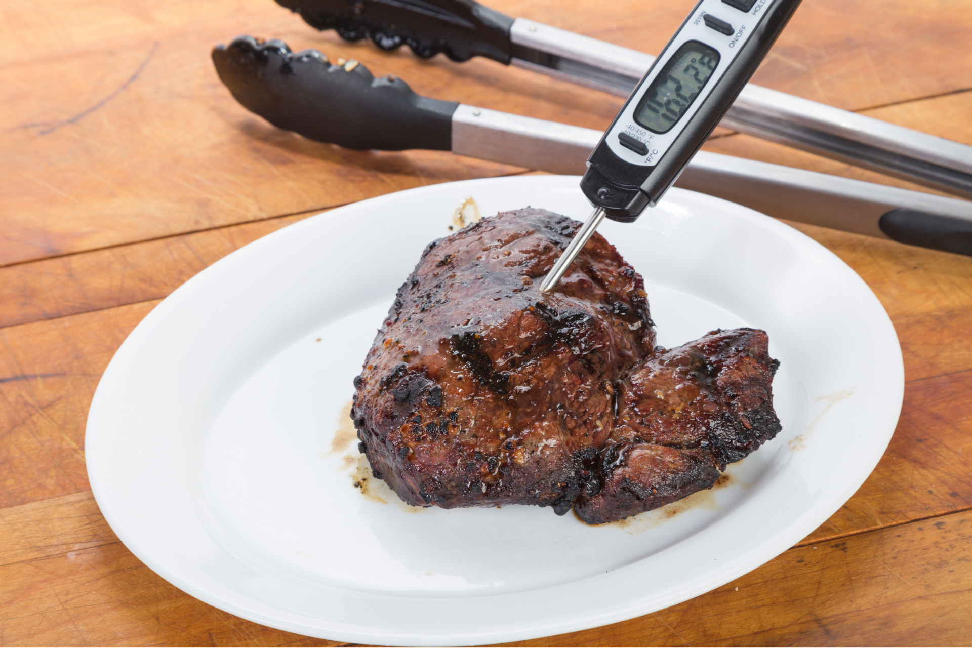 Kitchen staff checking internal temperature of food with bimetallic thermometer