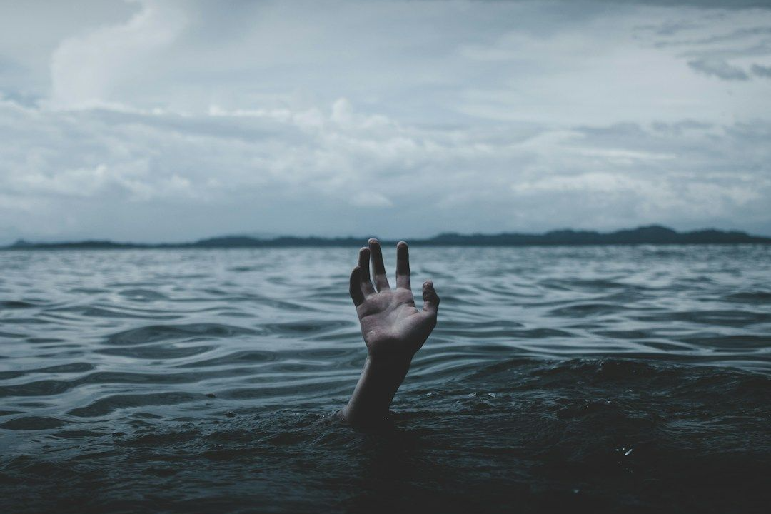 dark ocean with hand reaching up from the water