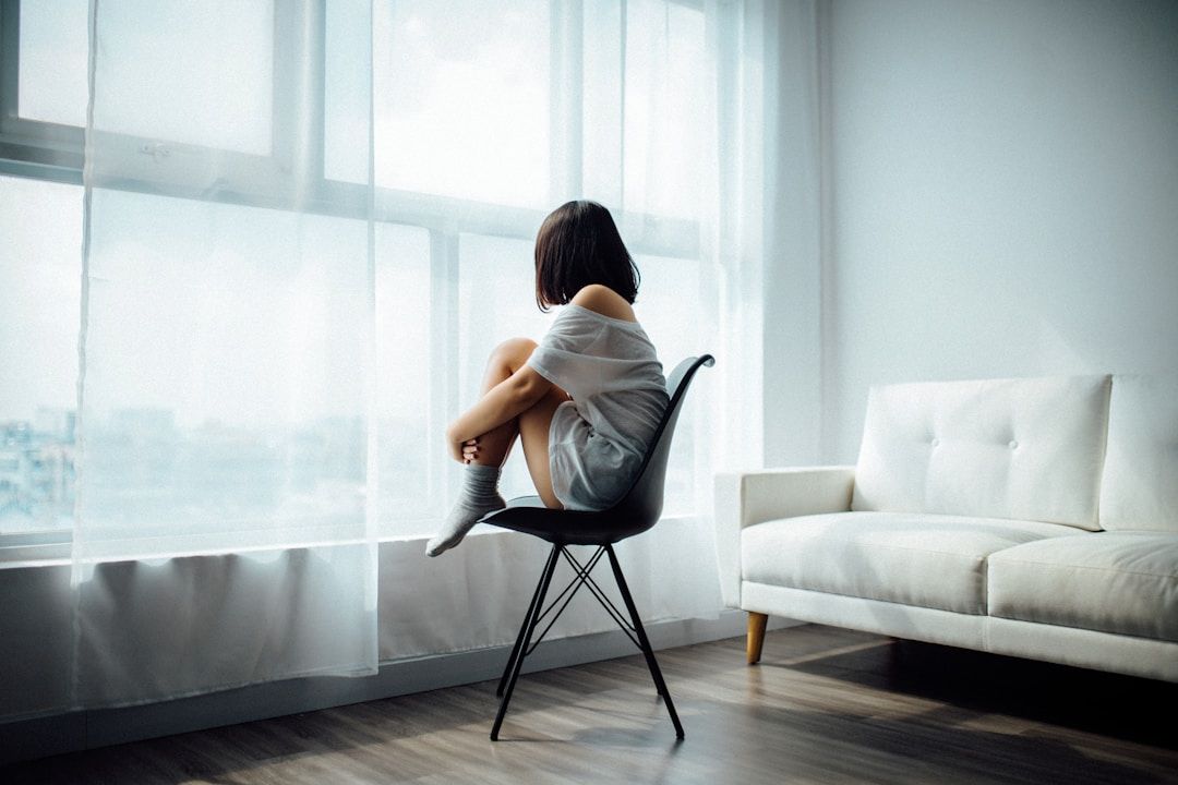woman sitting curled up in a chair gazing out the window