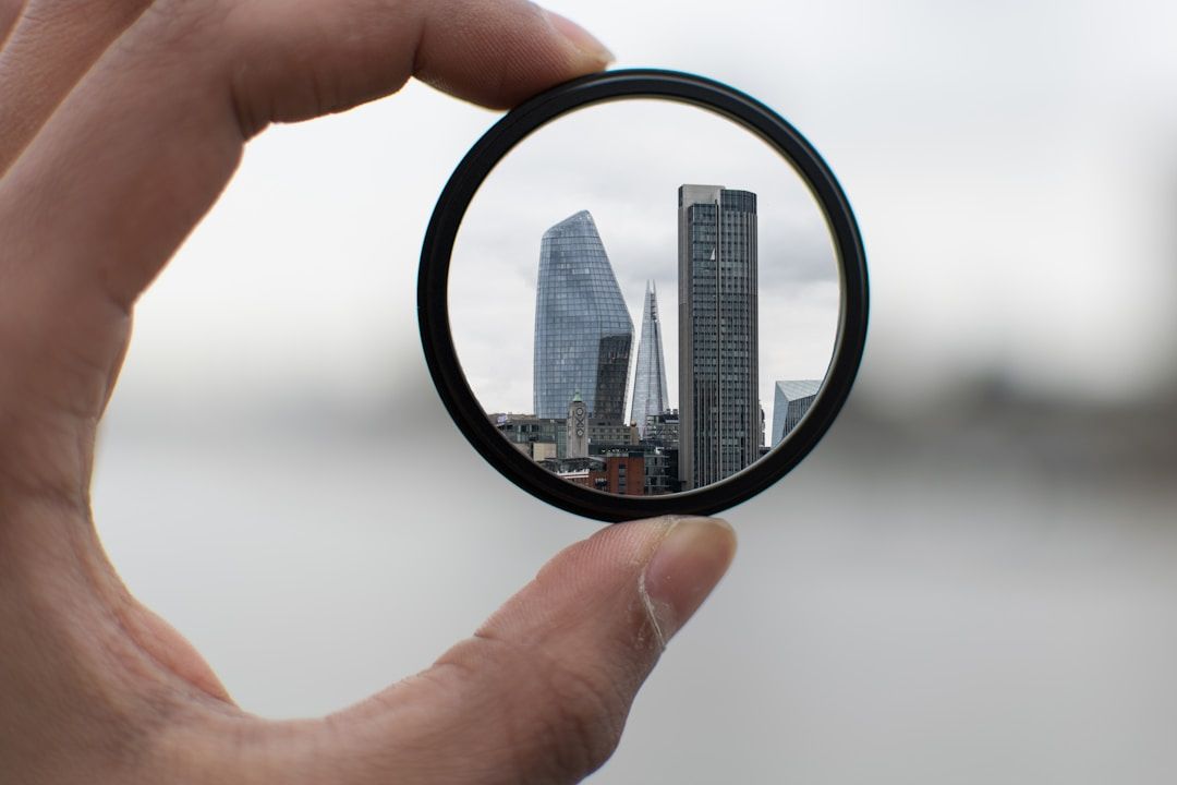 sky scrapers through a magnifying glass to represent the gift of gene key 13: discernment and seeing clearly