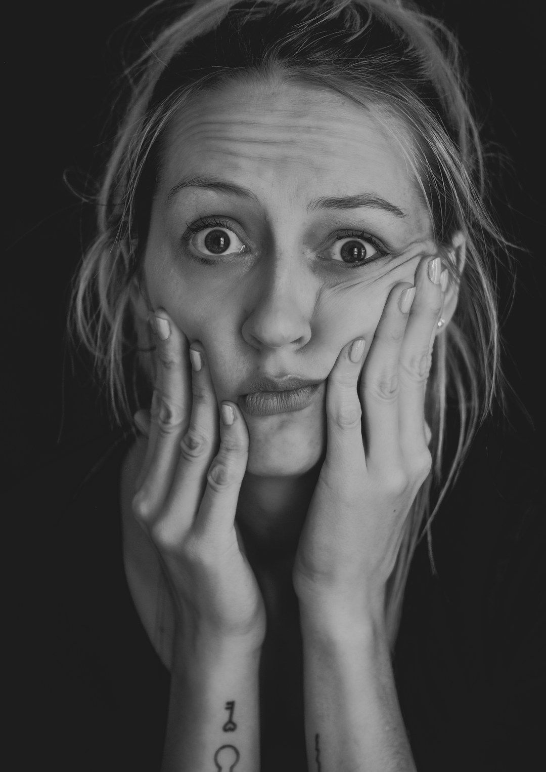 black background with a black and white photo of a woman looking confused to represent the shadow of gene key 2: dislocation