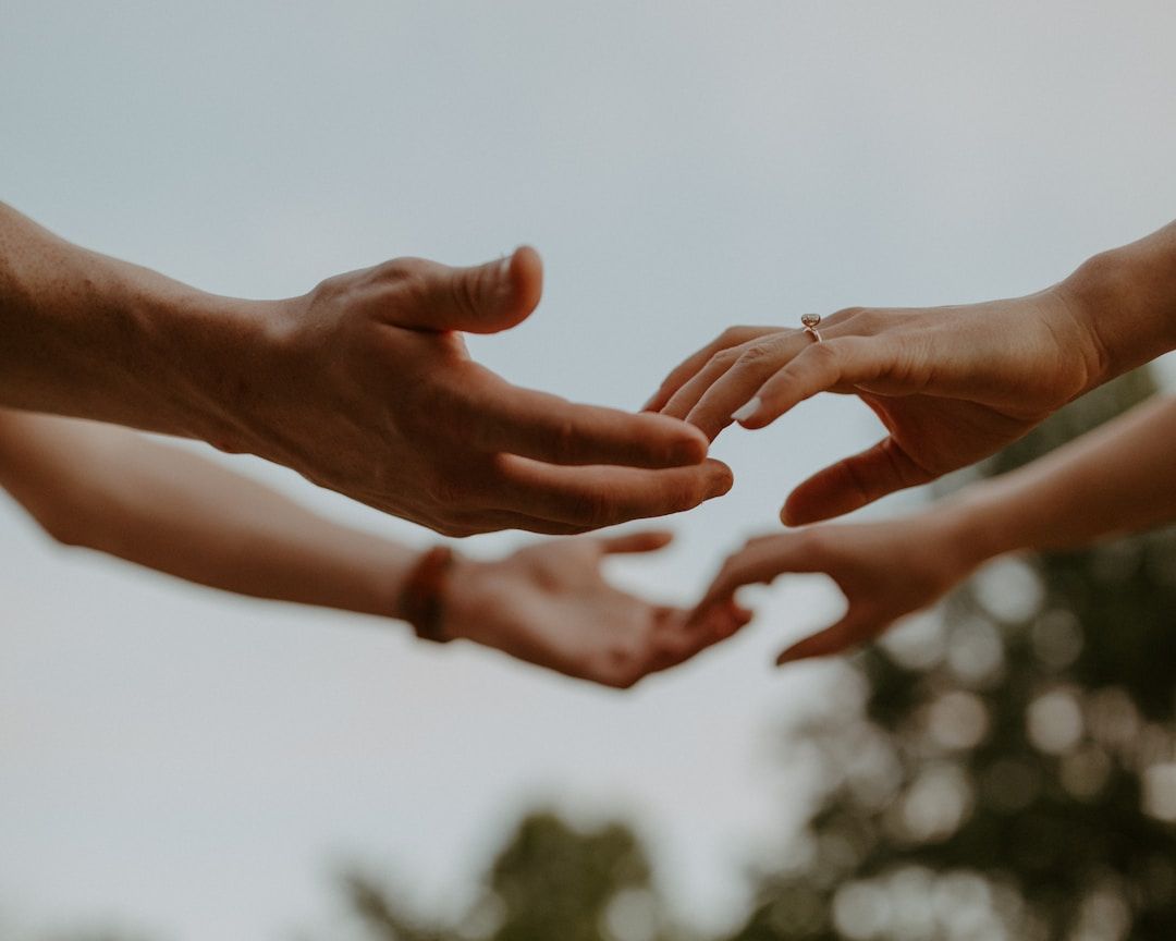 people reaching out to hold hands symbolizing human design gate 59 of intimacy and mating