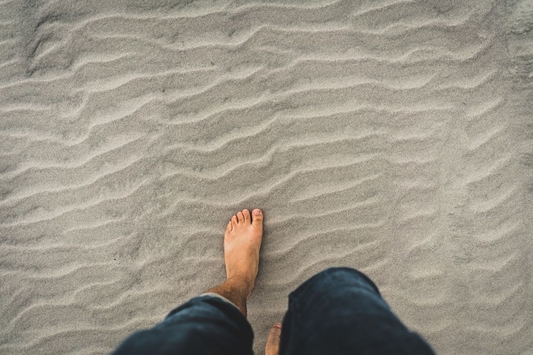 sandy beach with person taking a step forward into their healing journey