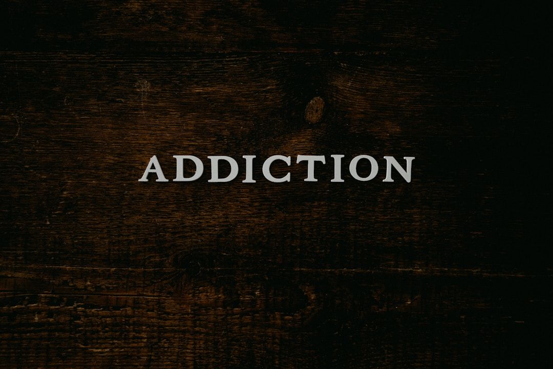black background with the word "addiction" in grey letters: the shadow of gene key 24