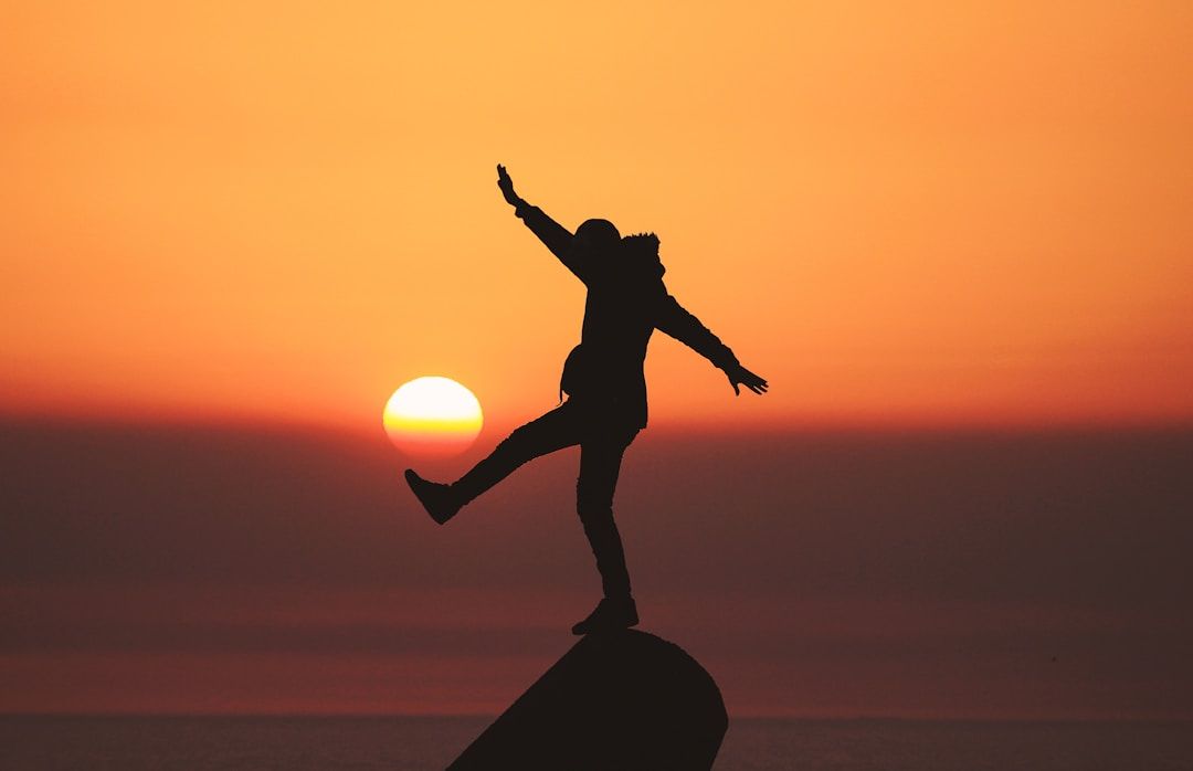 silhouette of a person that looks like they are kicking the sun
