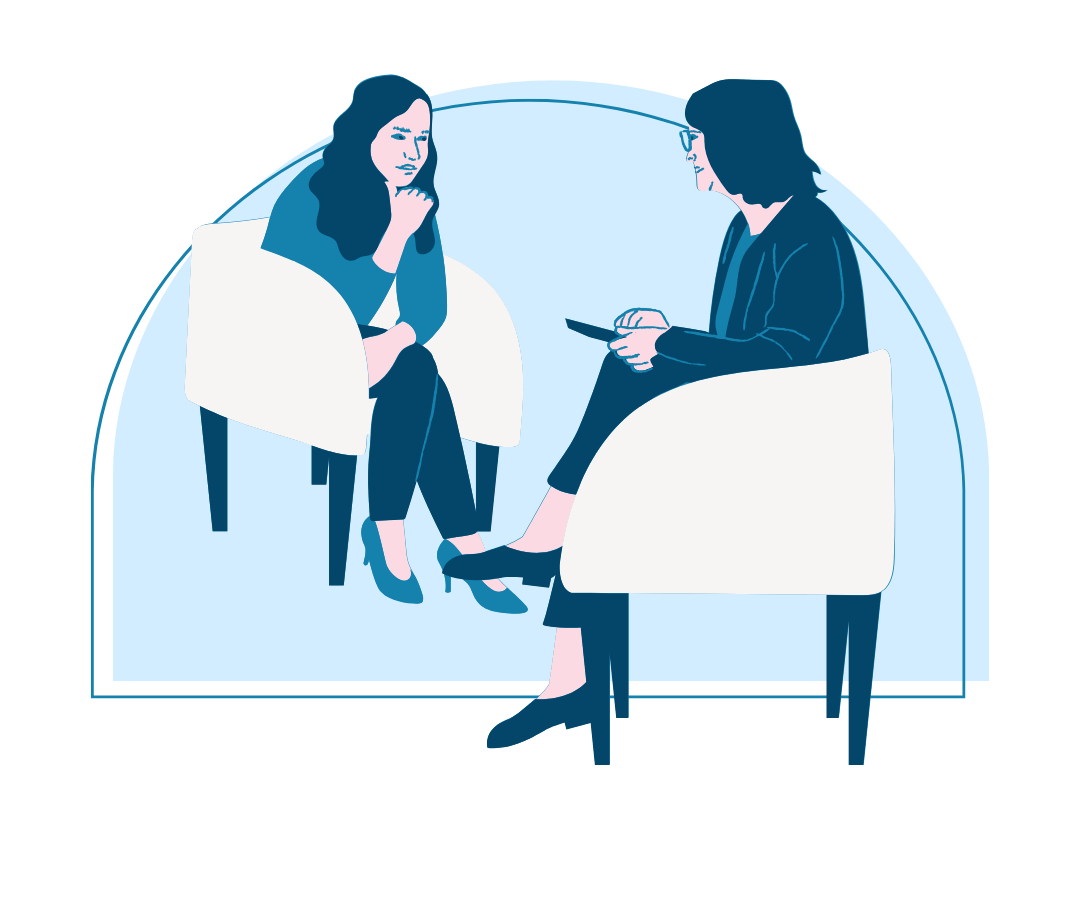 An illustration of two women sitting across from each other in conversation during a therapy or consultation session. One woman appears to be thoughtfully listening, with her hand resting near her chin, while the other holds a clipboard or tablet, engaging attentively. Both are seated in white chairs within a softly curved blue background, suggesting a calm and private setting.