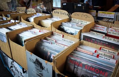 Photo of vinyl records organised in cardboard boxes in a record store.