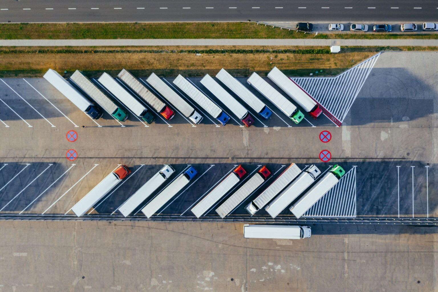 Aerial view of trucks parked in a large parking lot at a warehouse.