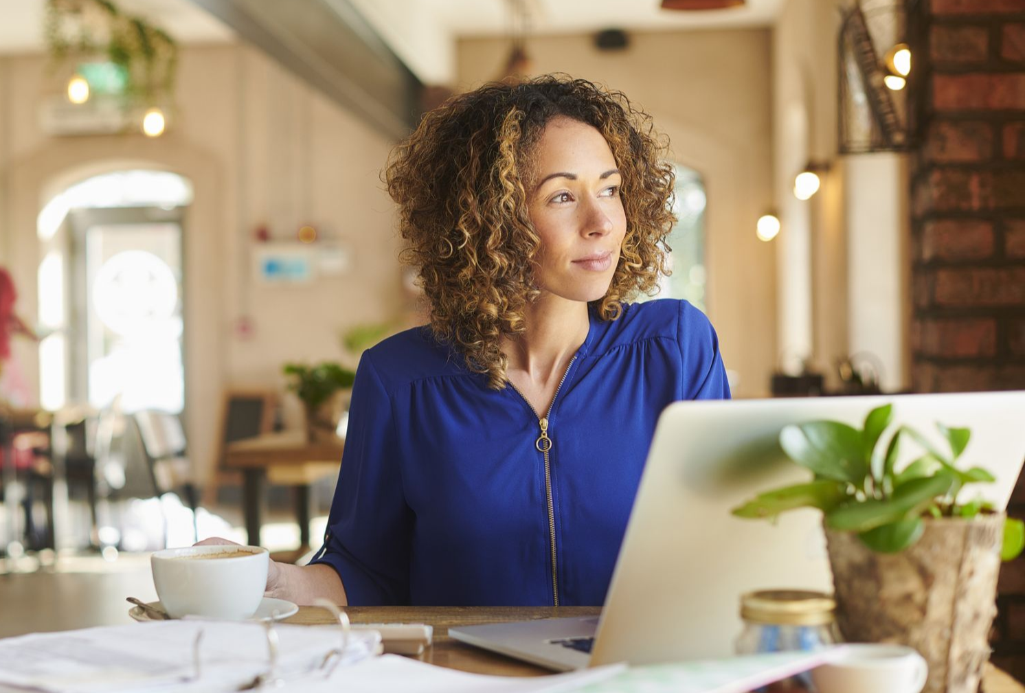 person using laptop with metrics graphics hovering above