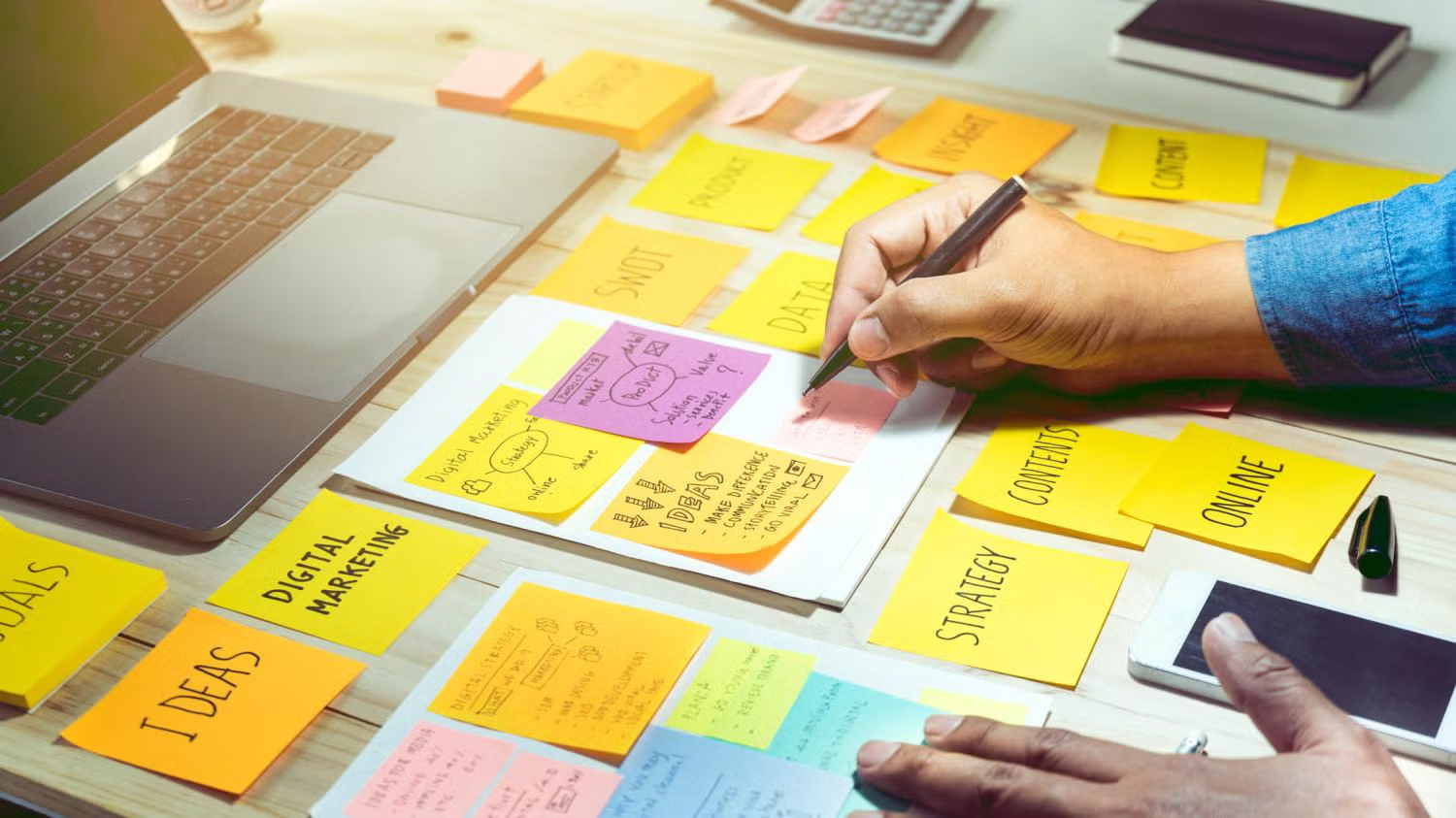 person planning using sticky notes on desk