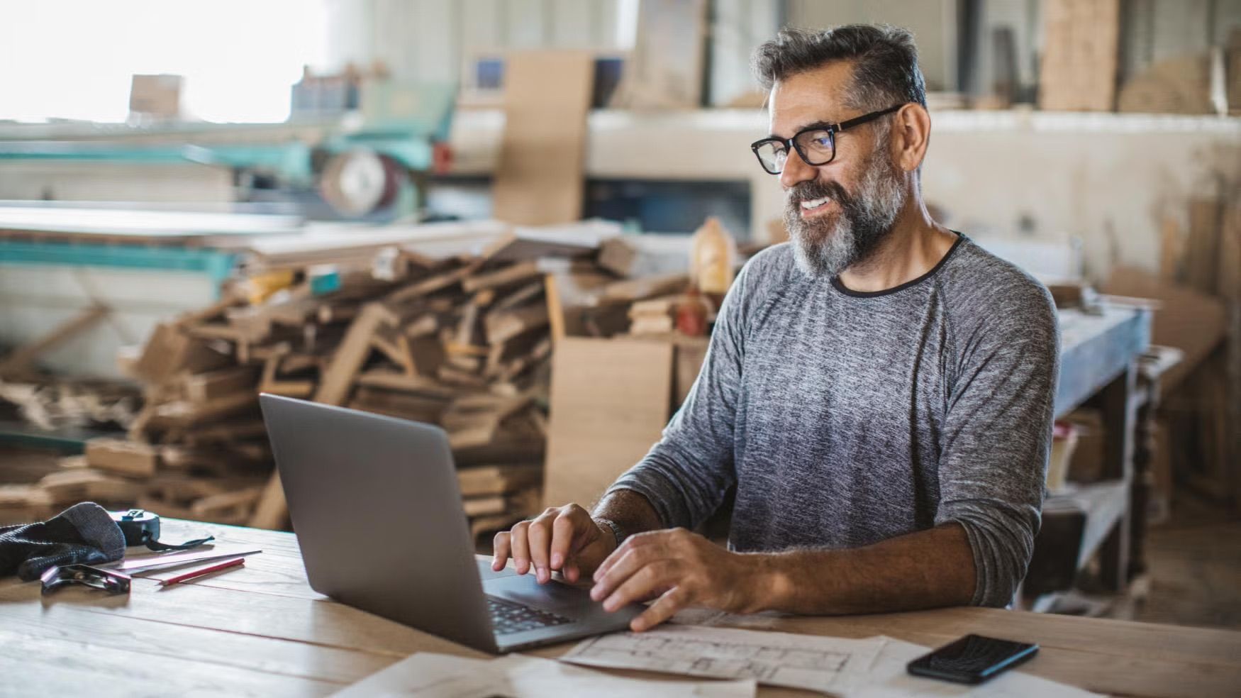 Business owner using laptop in workshop