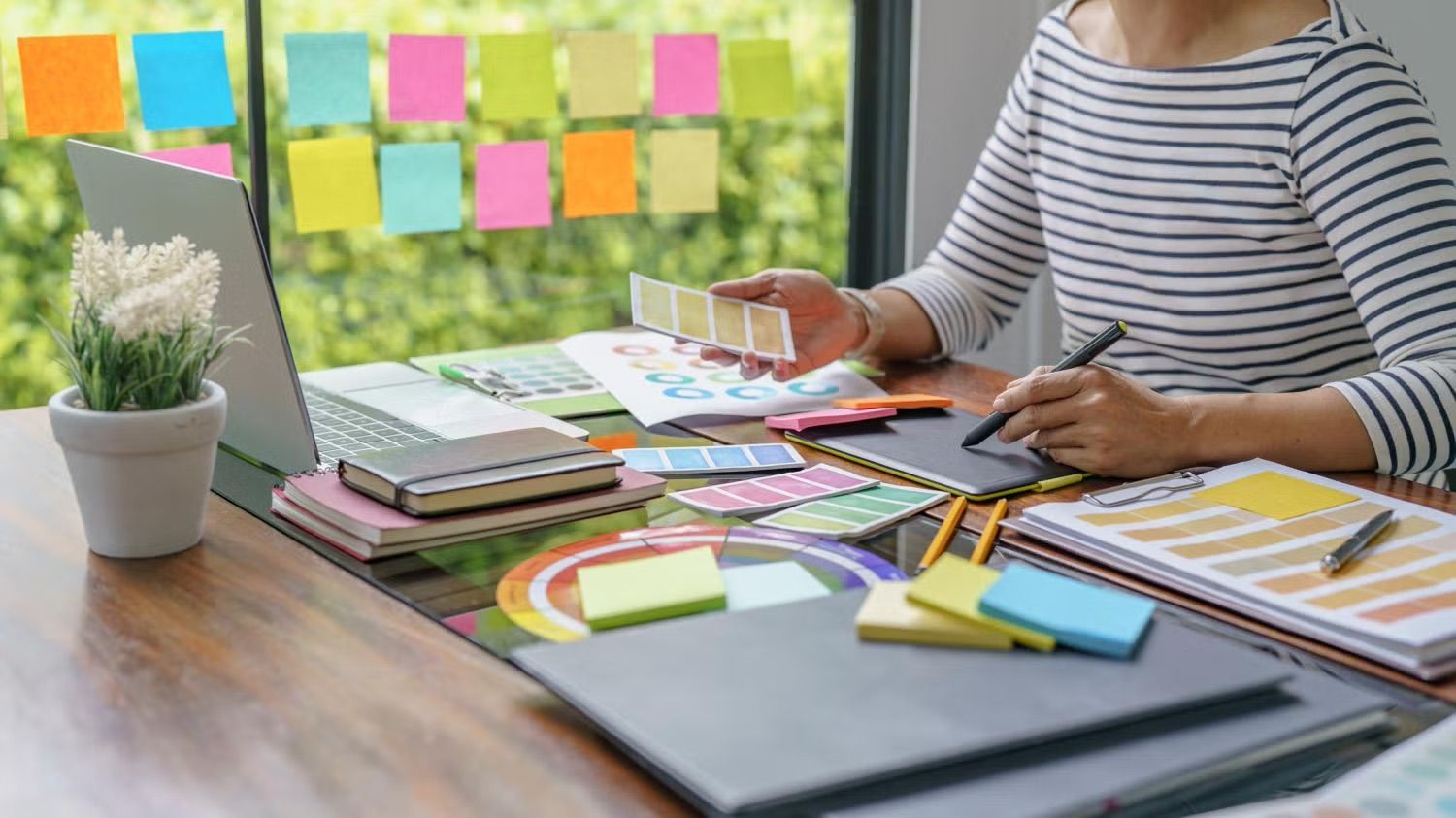 Businesswoman comparing color swatches at desk