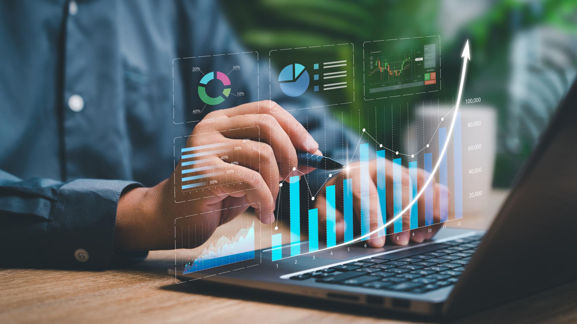 person using laptop with metrics graphics hovering above