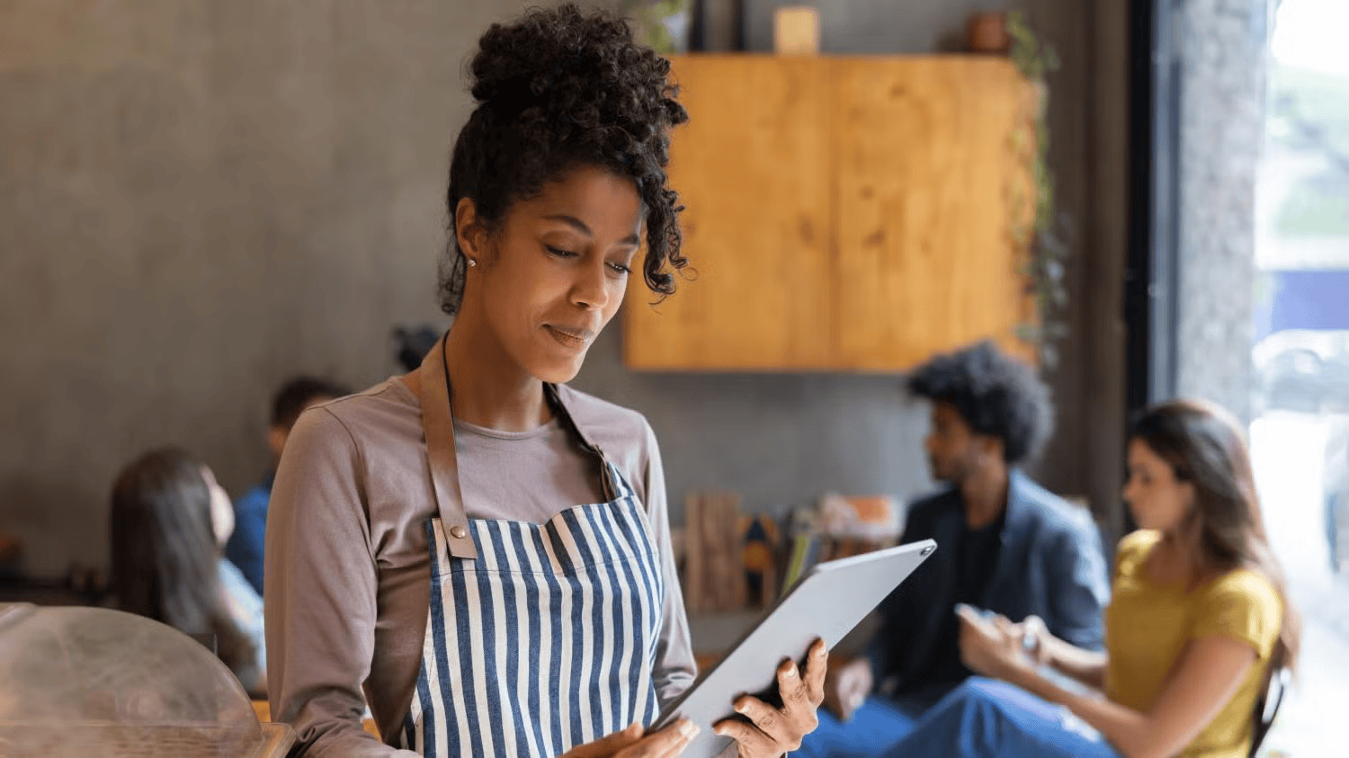 business owner wearing apron and using tablet