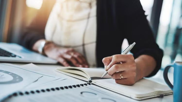 businesswoman writing in notebook