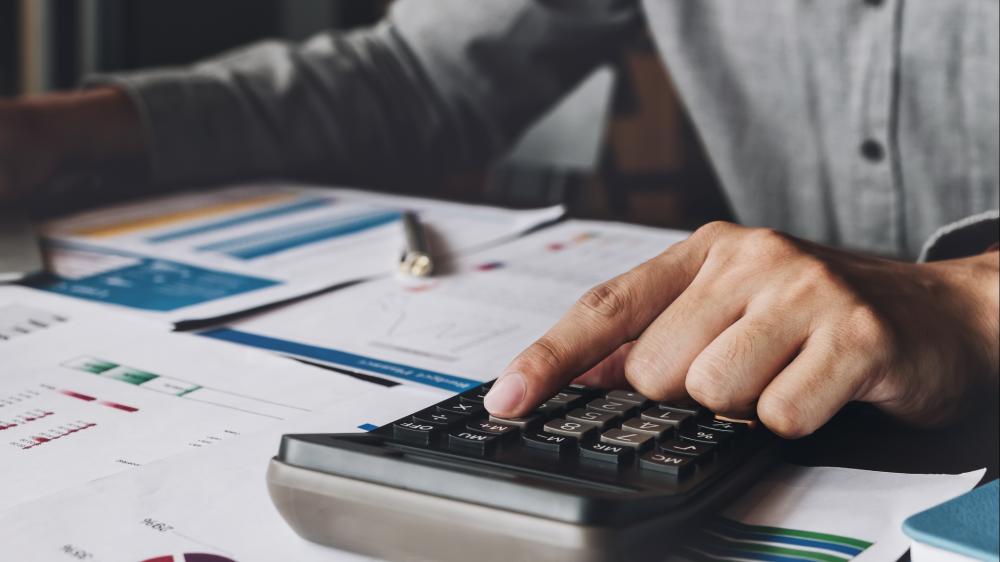 person using laptop with metrics graphics hovering above