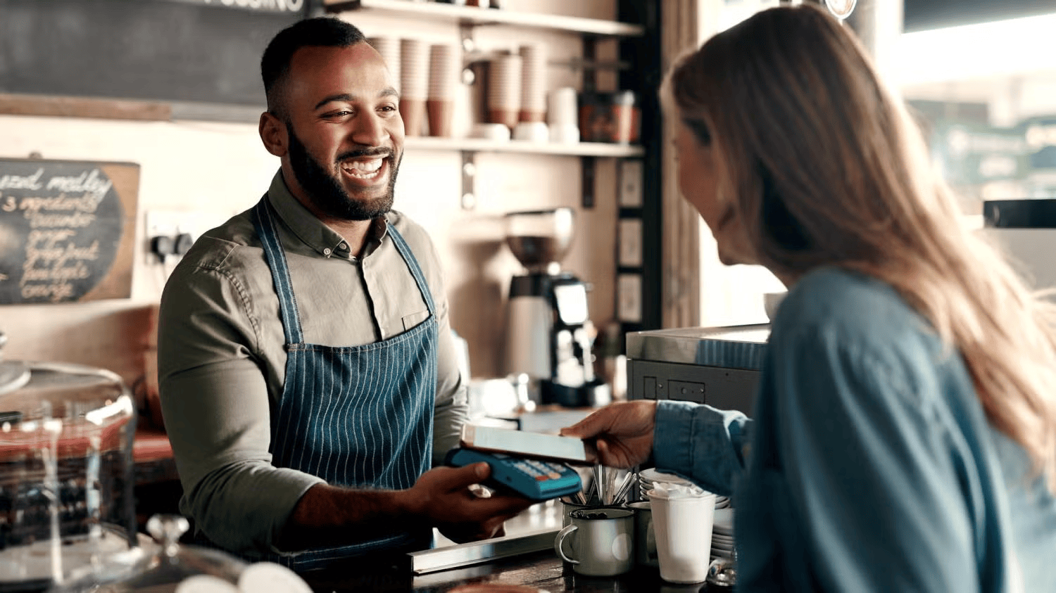business owner serving customer at coffee shop