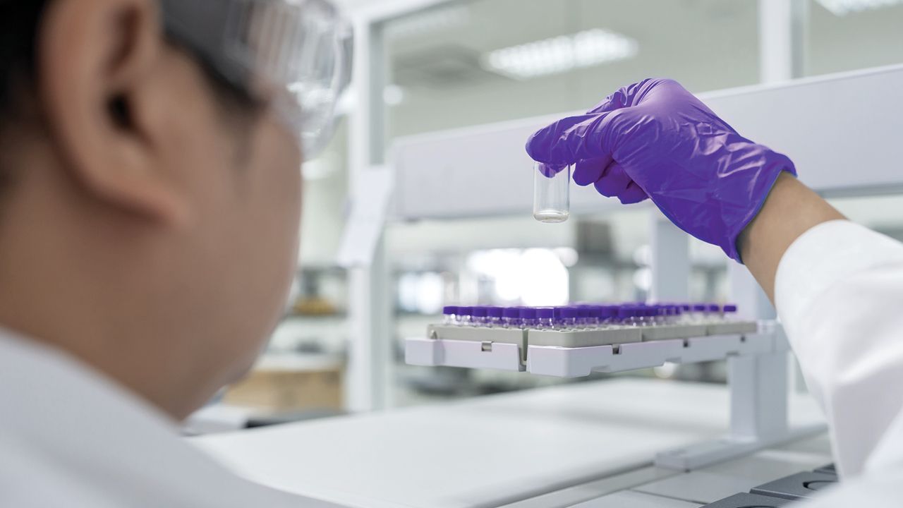 A lab scientist placing sample vials into lab equipment for analysis | Graphic for 'GC-MS for Operators and Developers' course from Analytical Training Solutions