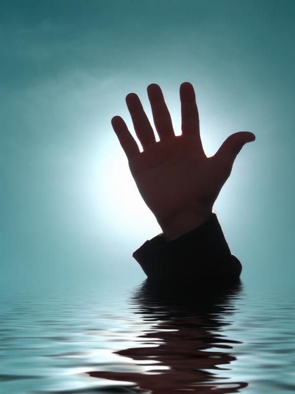 A hand reaches up out of dark water.