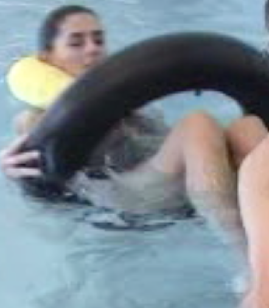 A client floats on a ring while a therapist guides the movement.