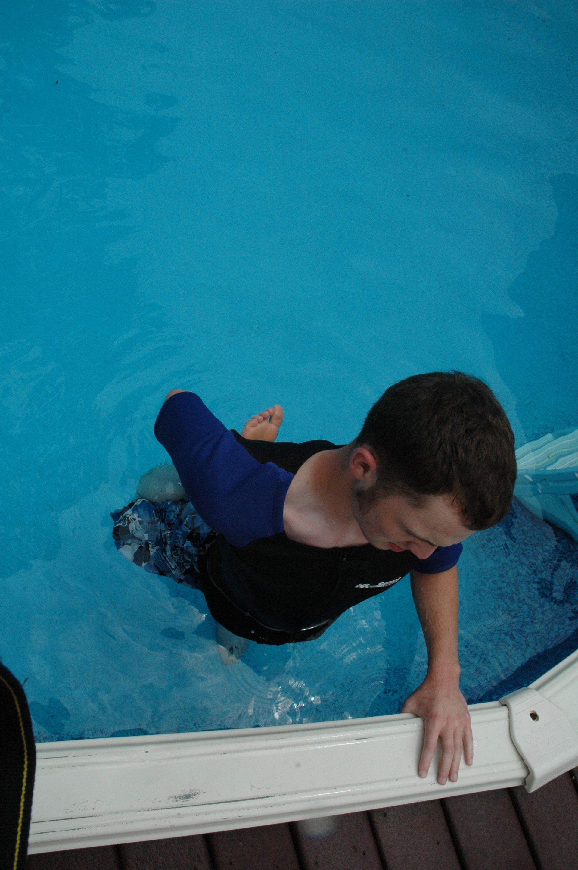 A man climbs out of a pool.
