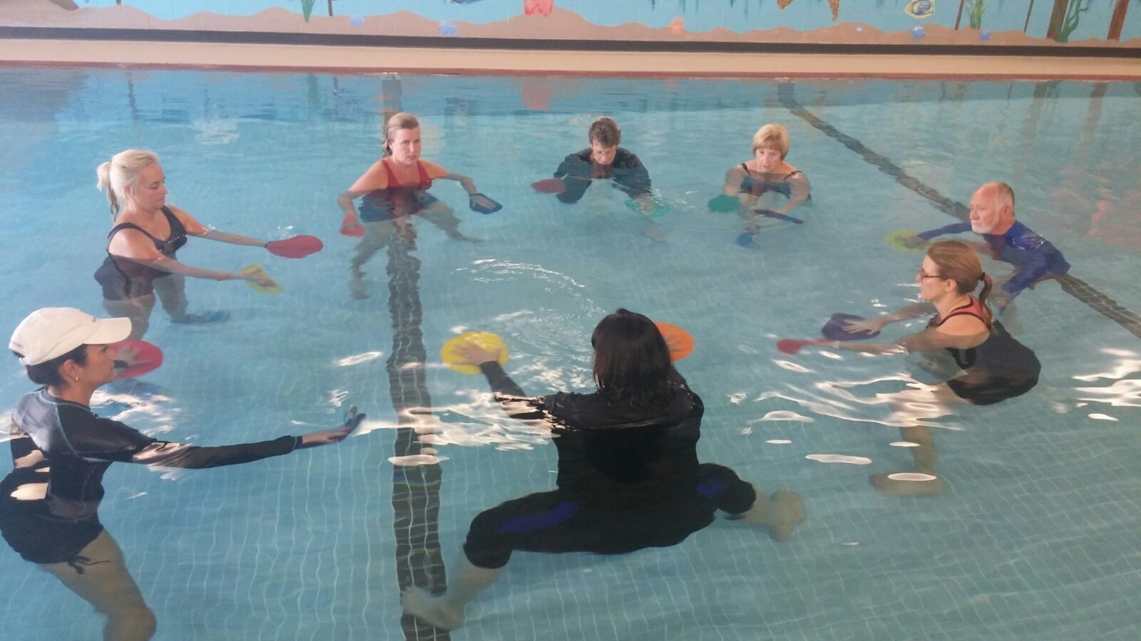 A group exercises in a large community pool.