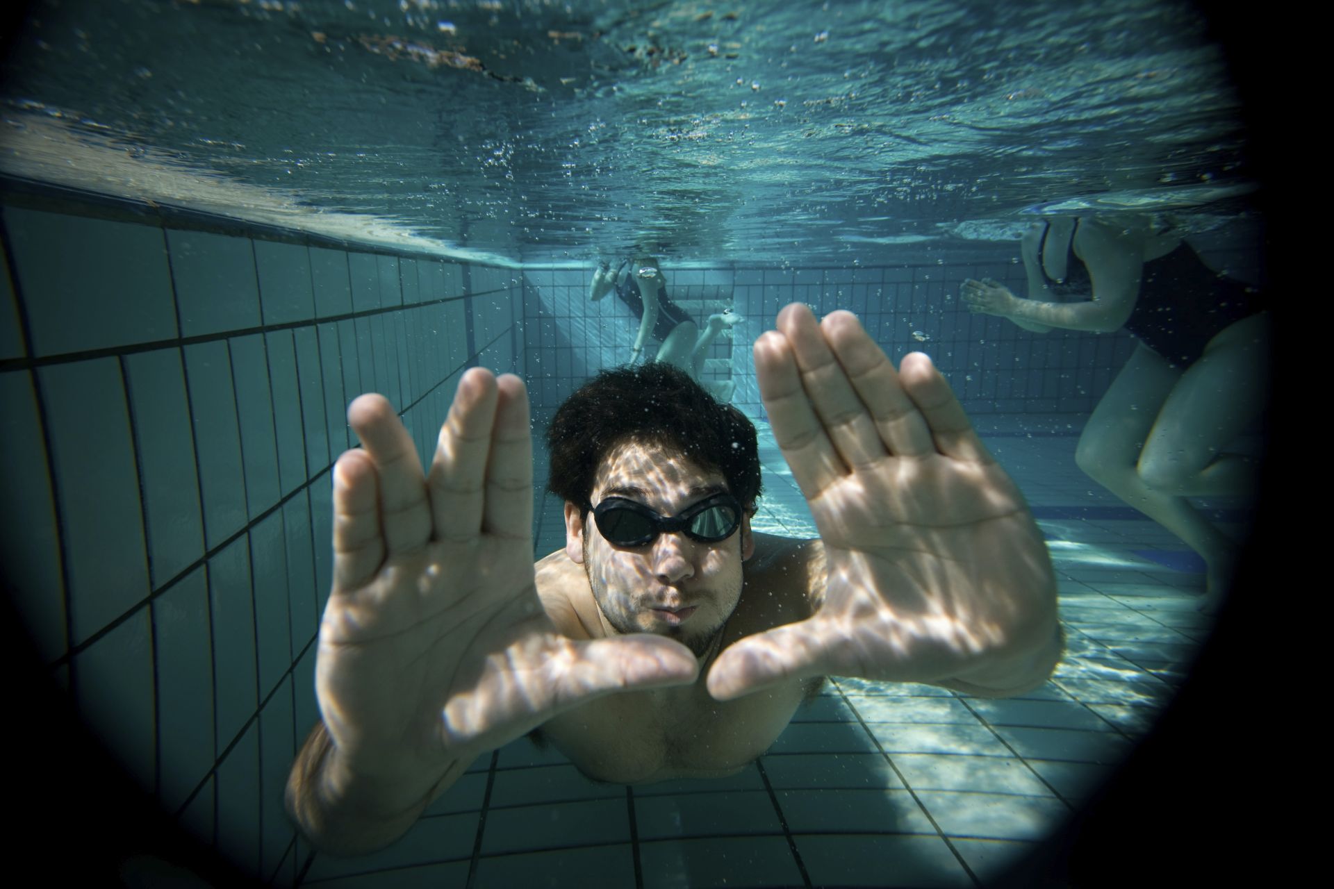 A swimmer underwater reaches toward the camera.