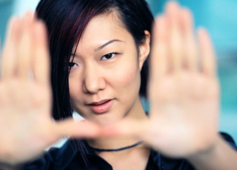 A woman frames the camera with her hands.