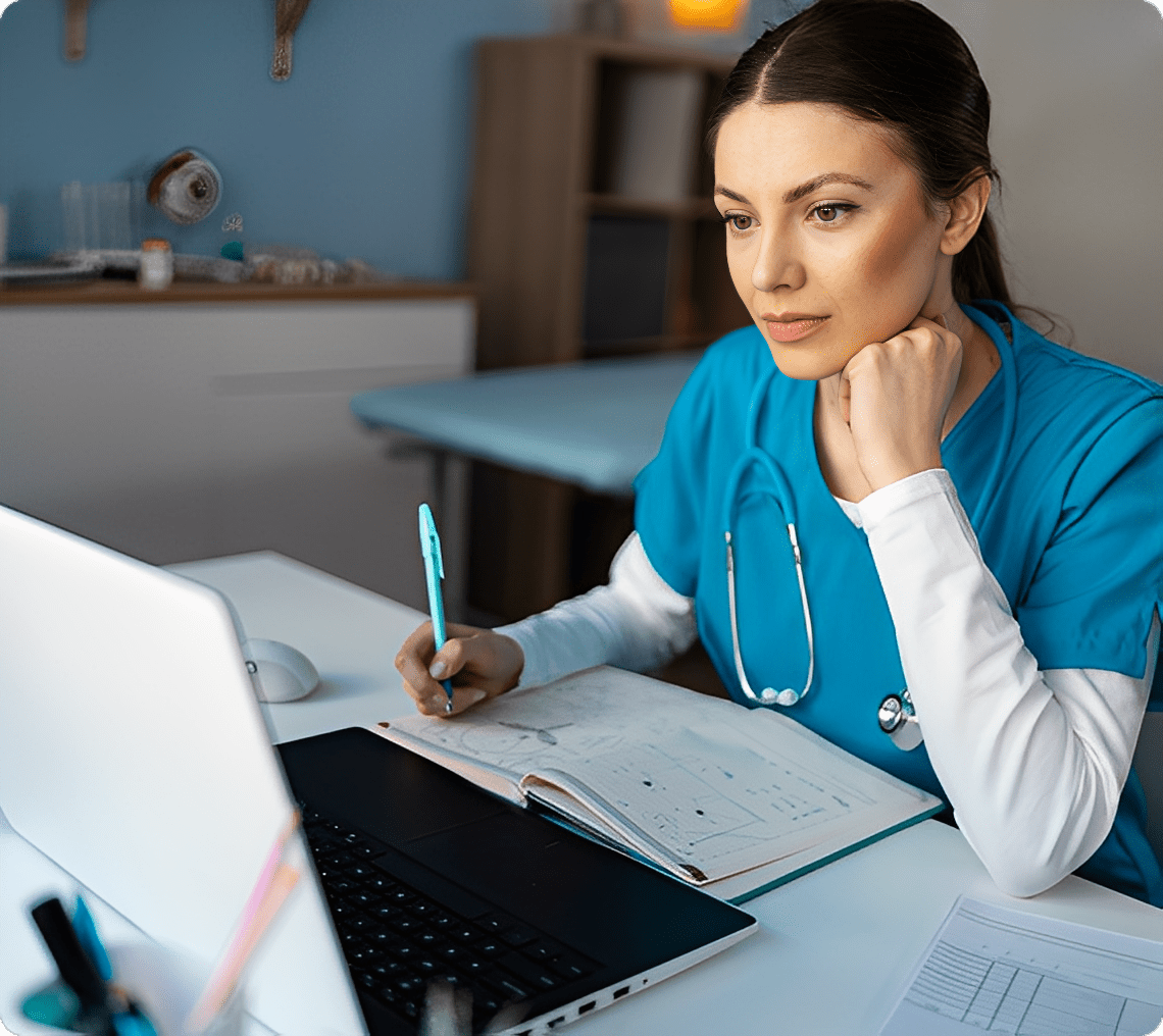 Female nurse reviewing patient information on a laptop.