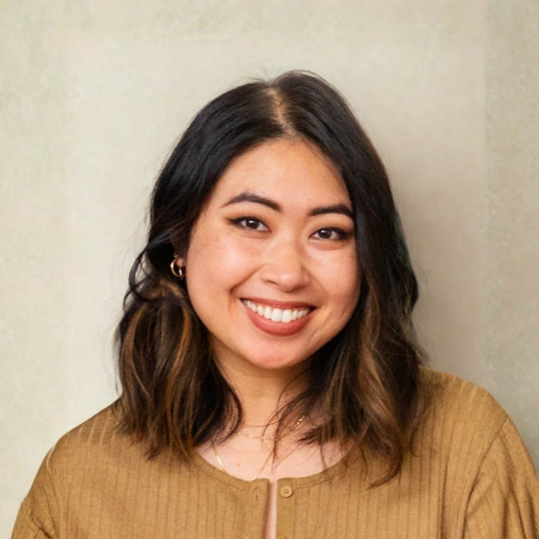 Tiffany Brackens in a black outfit, smiling against a beige background