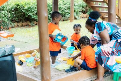 group of toddler children playing in sand box
