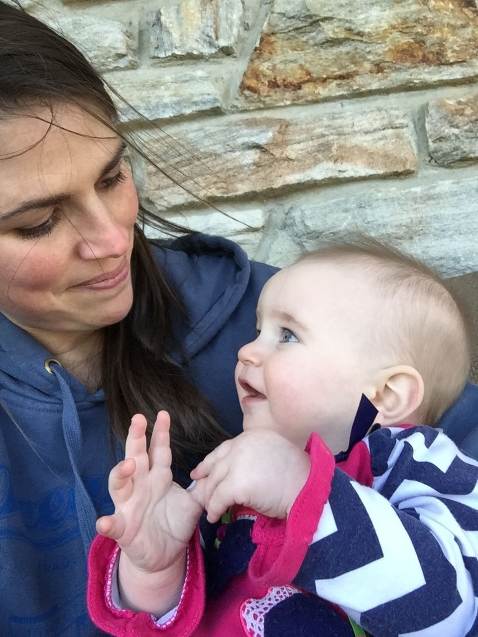 Baby being held by mother and signing "more"