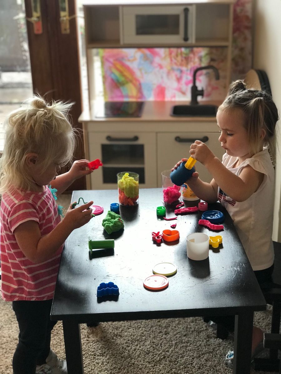 toddlers playing playdough at table