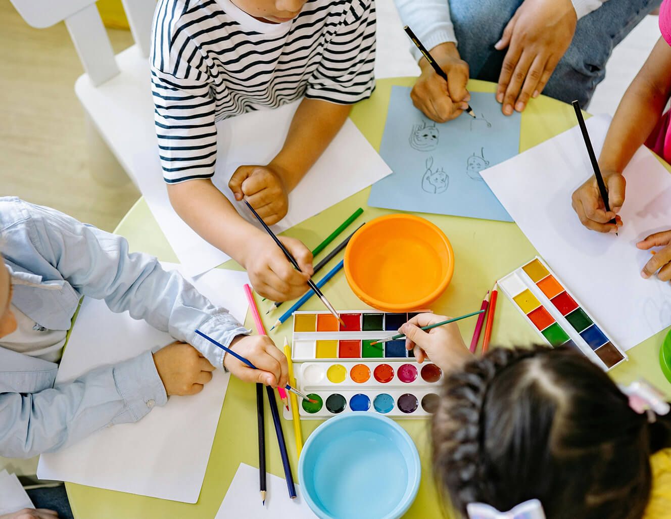 kids at table coloring with colored pencils