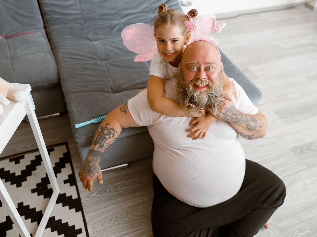 father and daughter on couch playing dress ups with butterfly outfits